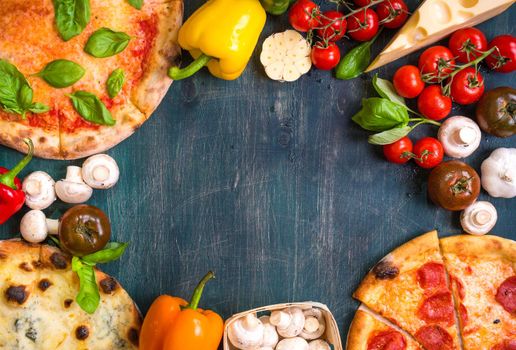 Pizza with assorted toppings and ingredients background. Space for text. Pizza, flour, cheese, tomatoes, basil, pepperoni, mushrooms and rolling pin over old wooden background. Top view. Food frame