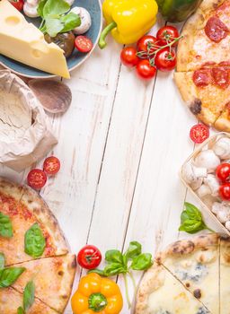 Pizza with assorted toppings and ingredients background. Space for text. Pizza, flour, cheese, tomatoes, basil, pepperoni, mushrooms and rolling pin over white wooden background. Top view. Food frame