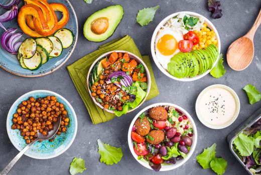 Mixed healthy vegetarian salads with vegetables, sweet potato, falafel, bulgur, avocado, eggs. Assorted buddha bowl salads. Vegetarian food. Healthy lunch/dinner. Salad in bowl. Ingredients for making