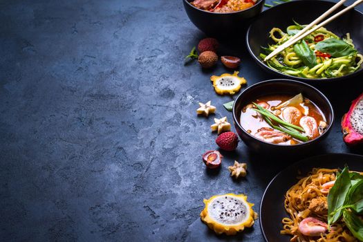 Thai food background. Dishes of thai cuisine. Tom yum soup, pad thai noodles, thai fried rice with pork and vegetables khao phat mu, green papaya salad som tam, thai fruits. Space for text