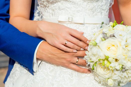 bride and groom holding hands with a bouquet