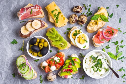 Assorted healthy sandwiches set background. Sandwich bar or buffet. Ciabatta sandwiches with dips, fish, cheese, meat, vegetables, fruits. Top view. Making sandwiches concept. Lunch time snacks