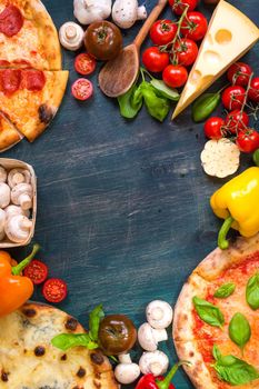 Pizza with assorted toppings and ingredients background. Space for text. Pizza, flour, cheese, tomatoes, basil, pepperoni, mushrooms and rolling pin over old wooden background. Top view. Food frame