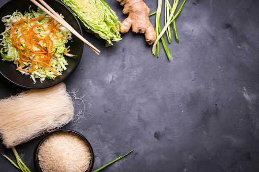 Ingredients for making chinese dinner: rice noodles, rice, napa cabbage, ginger, green onion. Asian cooking ingredients. Top view. Preparing healthy asian meal with vegetable salad. Space for text