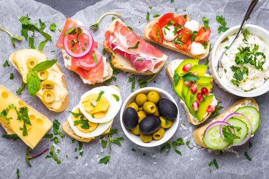 Assorted healthy sandwiches set background. Sandwich bar or buffet. Ciabatta sandwiches with dips, fish, cheese, meat, vegetables. Top view. Making sandwiches concept. Lunch time snacks. From above