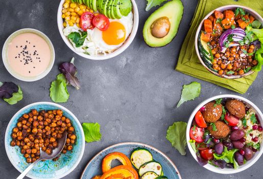 Mixed healthy vegetarian salads with vegetables, sweet potato, falafel, bulgur, avocado, eggs. Assorted buddha bowl salads background. Healthy dinner. Salad in bowl. Making ingredients. Space for text