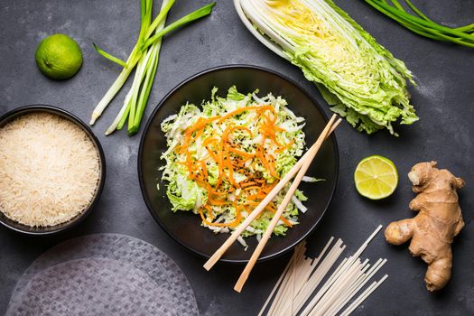 Vietnamese salad. Fresh ingredients for cooking vietnamese dinner: rice paper, rice, noodles, green onion, napa cabbage, salad. Asian cooking ingredients. Top view. Healthy vietnamese or asian dinner