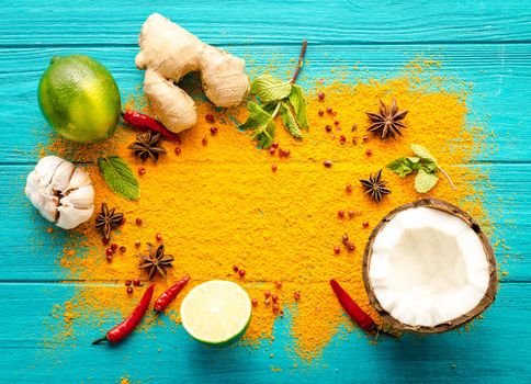 Thai food background. Ingredients for making thai food. Coconut, ginger, hot pepper, lime, curry, herbs, spices. Thai cuisine ingredients on blue wooden background. Space for text. Top view. Close-up