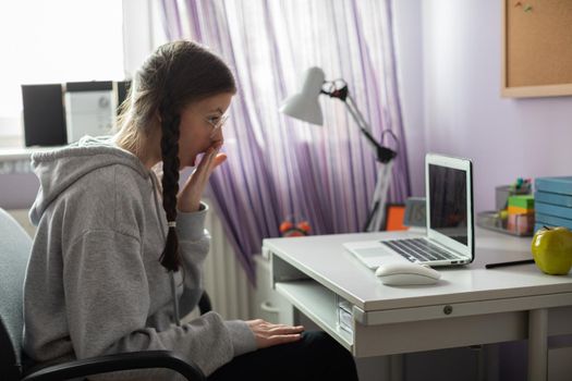 A school girl found unbelievable news about her peers on the internet. A young girl with pigtails.