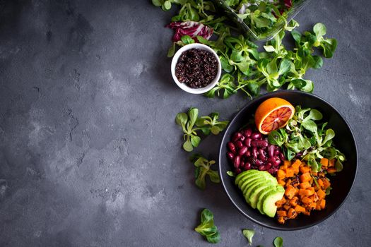 Fresh quinoa organic vegetables salad in bowl on concrete rustic background. Quinoa superfood concept. Clean healthy detox eating. Vegan/vegetarian food. Making healthy salad. Space for text. Top view