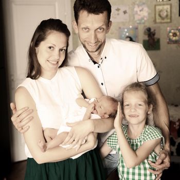 dad,daughter and mom with a newborn baby in the room for children