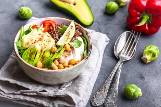 Bowl with healthy salad. Bowl with mix of chickpea, avocado, chicken, quinoa seeds, red bell pepper, fresh spinach, lime. Clean healthy eating concept. Buddha bowl. Healthy meal or snack. Close-up