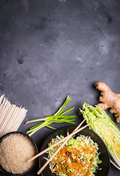 Ingredients for making chinese dinner: wheat noodles, rice, napa cabbage, ginger, green onion. Asian cooking ingredients. Top view. Preparing healthy asian meal with vegetable salad. Space for text