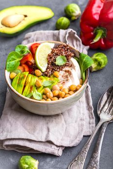 Bowl with healthy salad. Bowl with mix of chickpea, avocado, chicken, quinoa seeds, red bell pepper, fresh spinach, lime. Clean healthy eating concept. Buddha bowl. Healthy meal or snack. Close-up