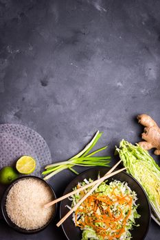 Ingredients for cooking vietnamese dinner: rice paper, rice, napa cabbage, ginger, green onion, salad. Asian cooking ingredients. Top view. Making vietnamese vegetable spring rolls. Space for text