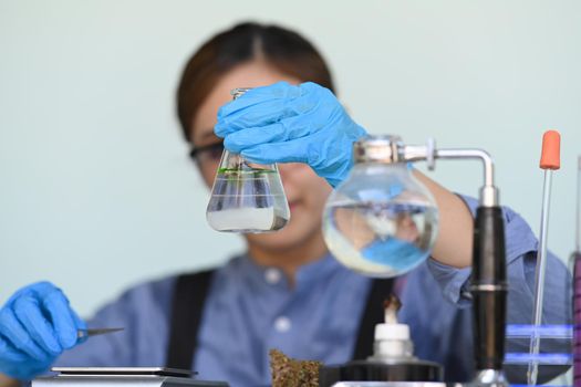 Researcher conducting scientific research in science lab. Herbal alternative medicine, cbd oil, pharmaceutical industry concept.