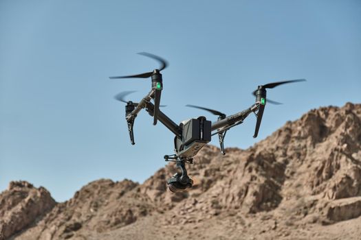 A professional drone flies in mountains and shoots a video,