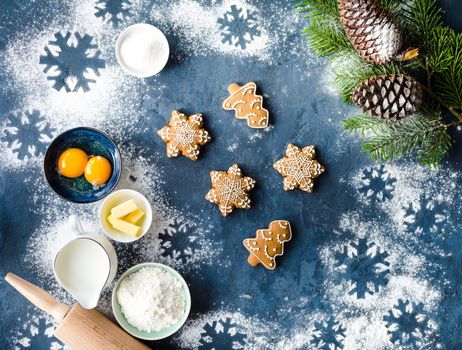 Christmas/New Year food background. Baking ingredients, snowflake cookies, Christmas decoration, gift bag. Making festive New Year gingerbread cookies. Flour, rolling pin, milk, eggs. Top view.