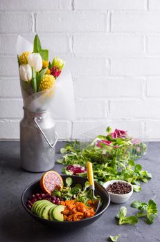 Table with fresh clean organic food. Quinoa vegetables salad bowl, salad leaves, flowers bouquet. Superfood or detox eating concept. Spring setting. Vegan/vegetarian food. Make salad. Space for text