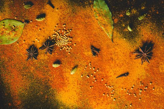 Assorted spices on dark black background. Seasonings for food. Curry, paprika, pepper, cardamom, anise, cloves, bay leaf, turmeric. Top view. Close-up. Spices concept. Spices ingredients for cooking