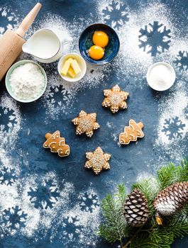 Christmas/New Year food background. Baking ingredients, snowflake cookies, Christmas decoration, gift bag. Making festive New Year gingerbread cookies. Flour, rolling pin, milk, eggs. Top view.