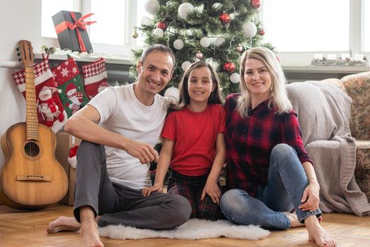 Christmas family. Happy mom, dad and little daughter. Enjoyng love hugs, holidays people. Togetherness concept.