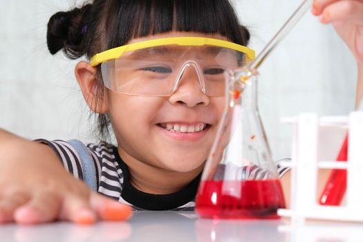 Children are learning and doing science experiments in the classroom. Little girl playing science experiment for home schooling. Easy and fun science experiments for kids at home.