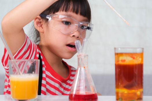 Children are learning and doing science experiments in the classroom. Little girl playing science experiment for home schooling. Easy and fun science experiments for kids at home.