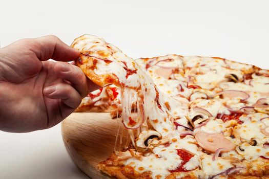 Man's hand takes a delicious slice of pizza with Margarita or Margarita with Mozzarella cheese, A man takes a slice of Italian pizza and pulls out an appetizing melted cheese.