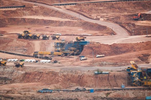 View of Trucks and excavators work in open pits in lignite coal mines. Lignite Coal Extraction Industry. The famous outdoor learning center of Mae Moh Mine Park, Lampang, Thailand.