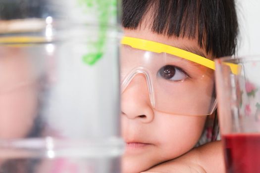 Children are learning and doing science experiments in the classroom. Little girl playing science experiment for home schooling. Easy and fun science experiments for kids at home.