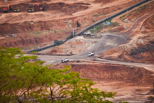 View of Trucks and excavators work in open pits in lignite coal mines. Lignite Coal Extraction Industry. The famous outdoor learning center of Mae Moh Mine Park, Lampang, Thailand.