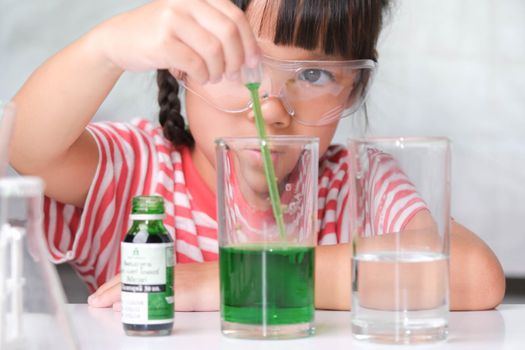 Children are learning and doing science experiments in the classroom. Little girl playing science experiment for home schooling. Easy and fun science experiments for kids at home.