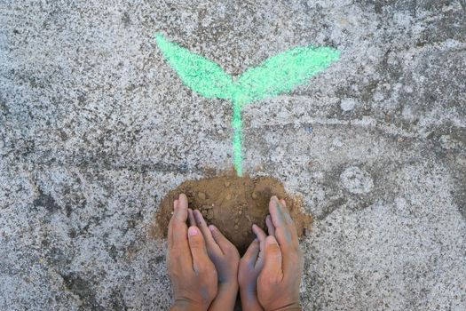 Young woman gesturing holding a drawing of a small tree on the ground in their hands. Concept of world environment day.