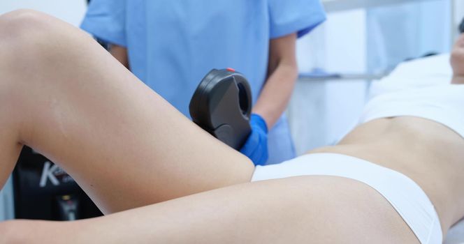 Doctor doing laser hair removal of legs of female client closeup 4k movie. Beauty industry concept