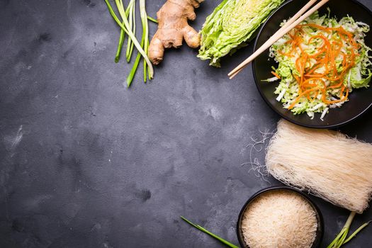 Ingredients for making chinese dinner: rice noodles, rice, napa cabbage, ginger, green onion. Asian cooking ingredients. Top view. Preparing healthy asian meal with vegetable salad. Space for text