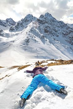 Acrophobia woman lie on top of a snowy mountain cliff edge. Fighting the fear of heights concept. Copy space, vertical