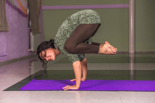 Yoga master shows yoga exercises ./Yogi presents yoga lassons in a studio.