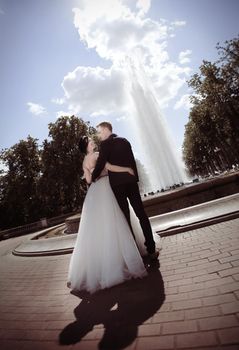 rear view. happy newlyweds standing in the square near the fountain