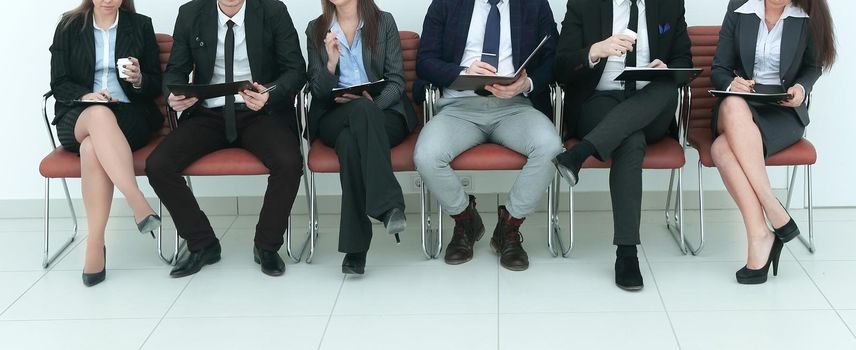 business team with clipboards sitting in a row .photo with copy space