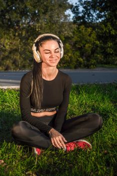 Fit girl listening to the music with headphones./Athletic girl listens to music .