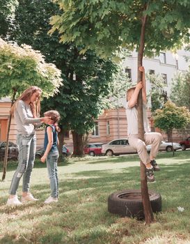 mother and children playing in the city yard. city life