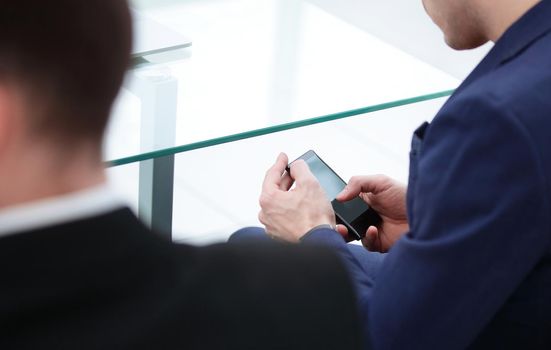 close up.businessman typing on a smartphone.