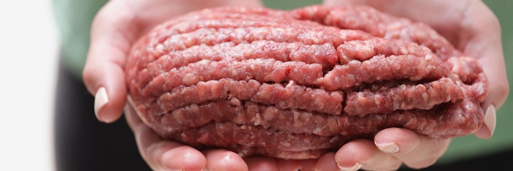 Female hands hold fresh red minced meat, close-up. Lean-fed animal meat, organic. BBQ Ingredients forcemeat