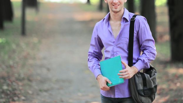 portrait of a successful student guy in a city Park.