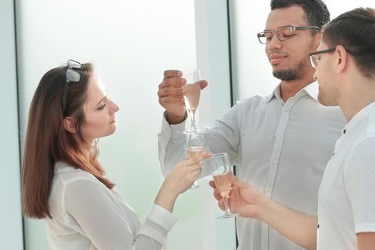 close up. business partners clink their glasses with wine. concept of success