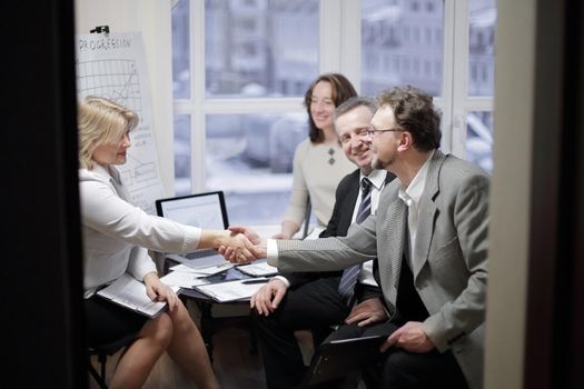 business handshake women with a partner over a Desk in the office