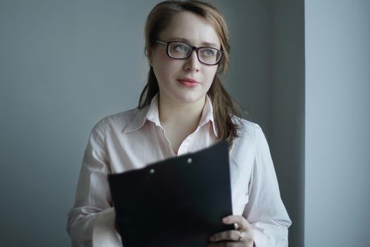 business woman reading a business document.isolated on grey background