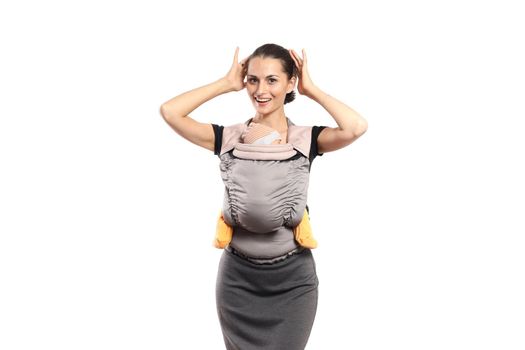 Babywearing beautiful young mother with baby in carrier, isolated on white. Free hands and active motherhood concept.