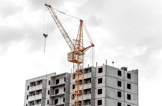A big yellow crane constructing a new high rise.